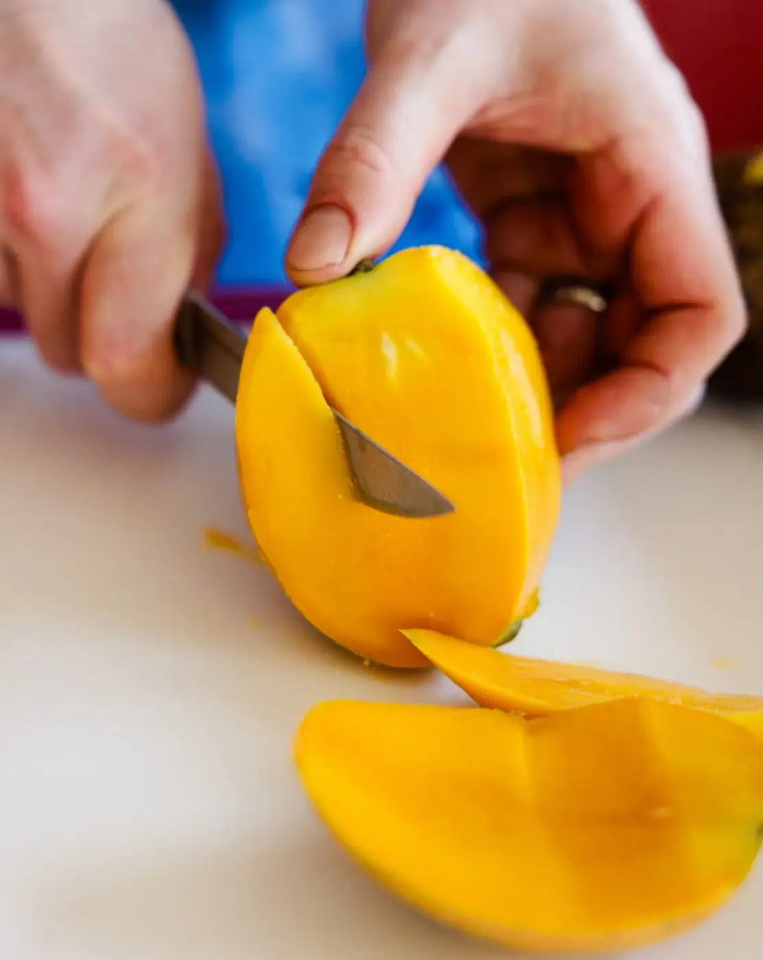A ripe mango being sliced